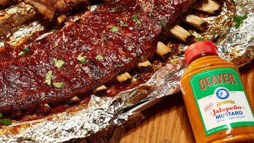 Rack of ribs on foil with Beaver Brand Jalapeño Mustard