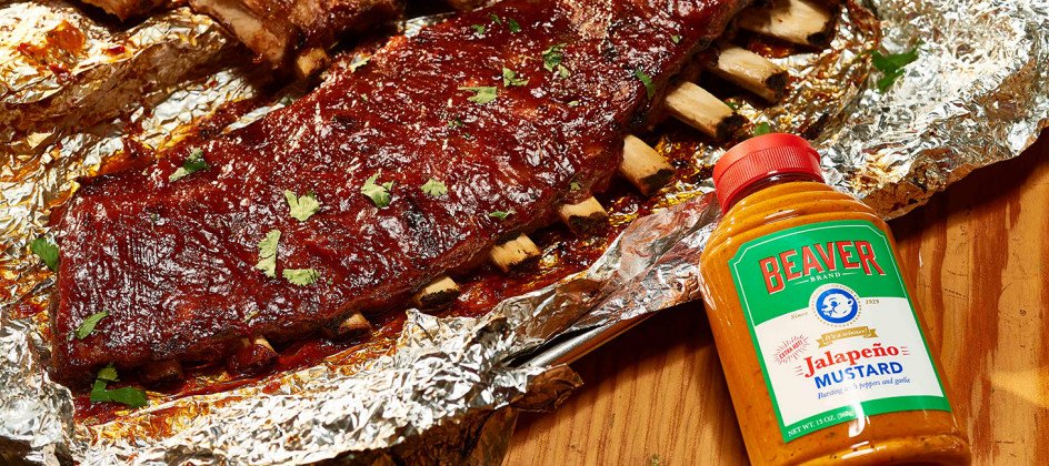 Rack of ribs on foil with Beaver Brand Jalapeño Mustard